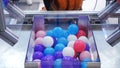 Large orange robotic hand relocating small plastic multicolored balls from one section to another. Media. Different Royalty Free Stock Photo