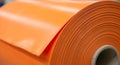 Large orange roll of plastic sheeting with a smooth surface. The edge features a Royalty Free Stock Photo