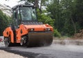 Large orange roller in the process of rolling hot asphalt Royalty Free Stock Photo