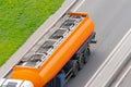 Large orange tank trailer tanker truck rolling on highway