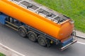 Large orange tank trailer tanker truck rolling on highway