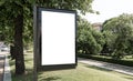 Large outdoor billboard mockup in park among trees. Brand, product, service advertisement targeted at pedestrians Royalty Free Stock Photo