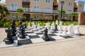 Large outdoor chess set beside a hotel at a tropical resort on a sunny day