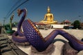 Large golden outdoor sitting Buddha Enshrined at a temple on the Chao Phraya River in Thailand.