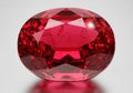 A large oval cut ruby gemstone on a gray background Royalty Free Stock Photo