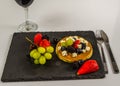 The large pancake with whipped cream and fresh fruit, strawberries, blueberries, blackberries, grapes, sweet red wine, black Royalty Free Stock Photo