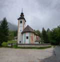 Large panoramic view Chuch St. John The Baptist in Lake Bohinj at cold, cloudy day Royalty Free Stock Photo