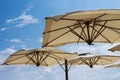 Large parasols. Beach season, time of rest and travel. Place for the text. Blue sky background. Beach umbrellas from the sun