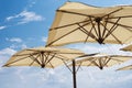 Large parasols. Beach season, time of rest and travel. Place for the text. Blue sky background. Beach umbrellas from the sun Royalty Free Stock Photo