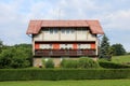 Large partially unfinished suburban family house with long balcony surrounded with grass and trees