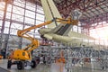 Large passenger aircraft on service in an aviation inside hangar rear view of the tail, on the auxiliary power unit.