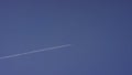 Large passenger supersonic plane flying high in clear blue sky, leaving long white trail. Airplane flying in white Royalty Free Stock Photo