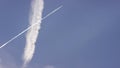 Large passenger supersonic plane flying high in clear blue sky, leaving long white trail. Airplane flying in white Royalty Free Stock Photo