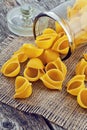 Large pasta shells in a glass jar on the background of jute