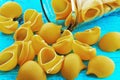 Large pasta shells in a glass jar on blue background