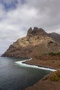 large pebble mountain by the calm sea in an arid environment of the canary islands under cloudy skies Royalty Free Stock Photo