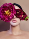 Large peonies near a woman face, art fashion flowers in front of a girl, nature face care, natural cosmetics