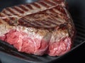A large piece of juicy fresh beef fried on one side in a pan-grill. Stripes-rare, the juice from the meat. Royalty Free Stock Photo