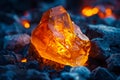 A large piece of orange rock on top of coal