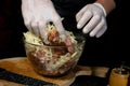 A large piece of pork is cut into pieces, marinated by the chef with spices, and the chef rubs the potatoes on a grater to the Royalty Free Stock Photo