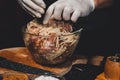 A large piece of pork is cut into pieces, marinated by the chef with spices, and the chef rubs the potatoes on a grater to the Royalty Free Stock Photo