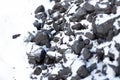 large pieces of coal under the snow. Fuel for the stove in winter. Heating a house in the countryside Royalty Free Stock Photo