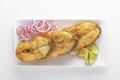 Large pieces of fried fish - pike perch with red onion and lime in a white plate on a light background. Royalty Free Stock Photo