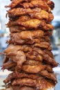Large pieces of meat on a spit at street food market in Thailand. Crilled skewered chiken meat on spit. Fast food