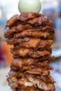 Large pieces of meat on a spit at street food market in Thailand. Crilled skewered chiken meat on spit. Fast food