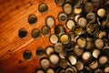 Large pile of beer bottle caps on wooden desk Royalty Free Stock Photo