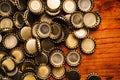 Large pile of beer bottle caps on wooden desk Royalty Free Stock Photo