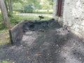 Large pile of black coat and soot next to white building and lake