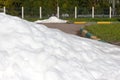 Large pile of dirty snow (ice) lies in the summer on the road an Royalty Free Stock Photo