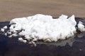 A large pile of dirty white snow lies on the asphalt road Royalty Free Stock Photo