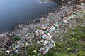 A large pile of garbage from plastic bottles on the shore of the lake Royalty Free Stock Photo