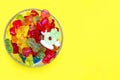 A large pile of multi-colored jelly gummy candies in a glass bowl on a yellow background Royalty Free Stock Photo