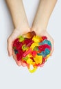 A large pile of multi-colored jelly marmalade candies in the hands of a child on a white background Royalty Free Stock Photo