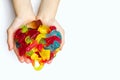 A large pile of multi-colored jelly marmalade candies in the hands of a child on a white background Royalty Free Stock Photo