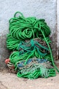 Large Pile Of Multicolor Heavily Used Thick Old Naval Ropes Mixed With Small Red Buoys Left Next To House Wall