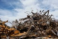 A large pile of rusty scrap metal in a landfill outside the city