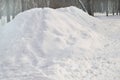 A large pile of snow piled in the Park for the construction of an ice slide, copy space, natural background Royalty Free Stock Photo