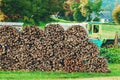 Large pile of stacked chopped firewood in farm back yard, ready for winter heating season