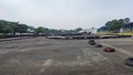 a large pile of used tires stacked in a haphazard way on a paved parking lot