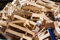 A large pile of wooden cardboard and plastic crates on a garbag