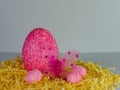 Large pink beaded Easter egg on a bed of yellow paper shreds with a pink mesh butterfly with gemstones and 3 smaller pink sequined