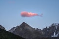 Large pink cloud like a whale floats across the evening sky over the mountains Royalty Free Stock Photo