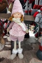 A large pink doll in a warm hat and with a scarf.
