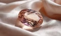 A large pink gemstone sits on a white cloth Royalty Free Stock Photo