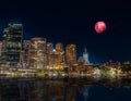 Large Pink moon rising behind Sydney CBD buildings NSW Australia