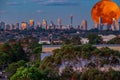 Large pink orange moon rising behind Sydney CBD buildings NSW Australia Royalty Free Stock Photo